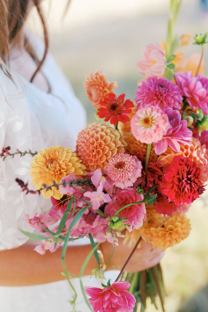 Bright pink and orange wedding bouquet by Bloom and Root Floral, taken by Julia Price Photography